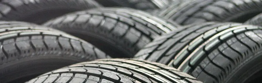 Pilha de pneus de carro com padrões de banda de rodagem relacionada a seguro de veículos.